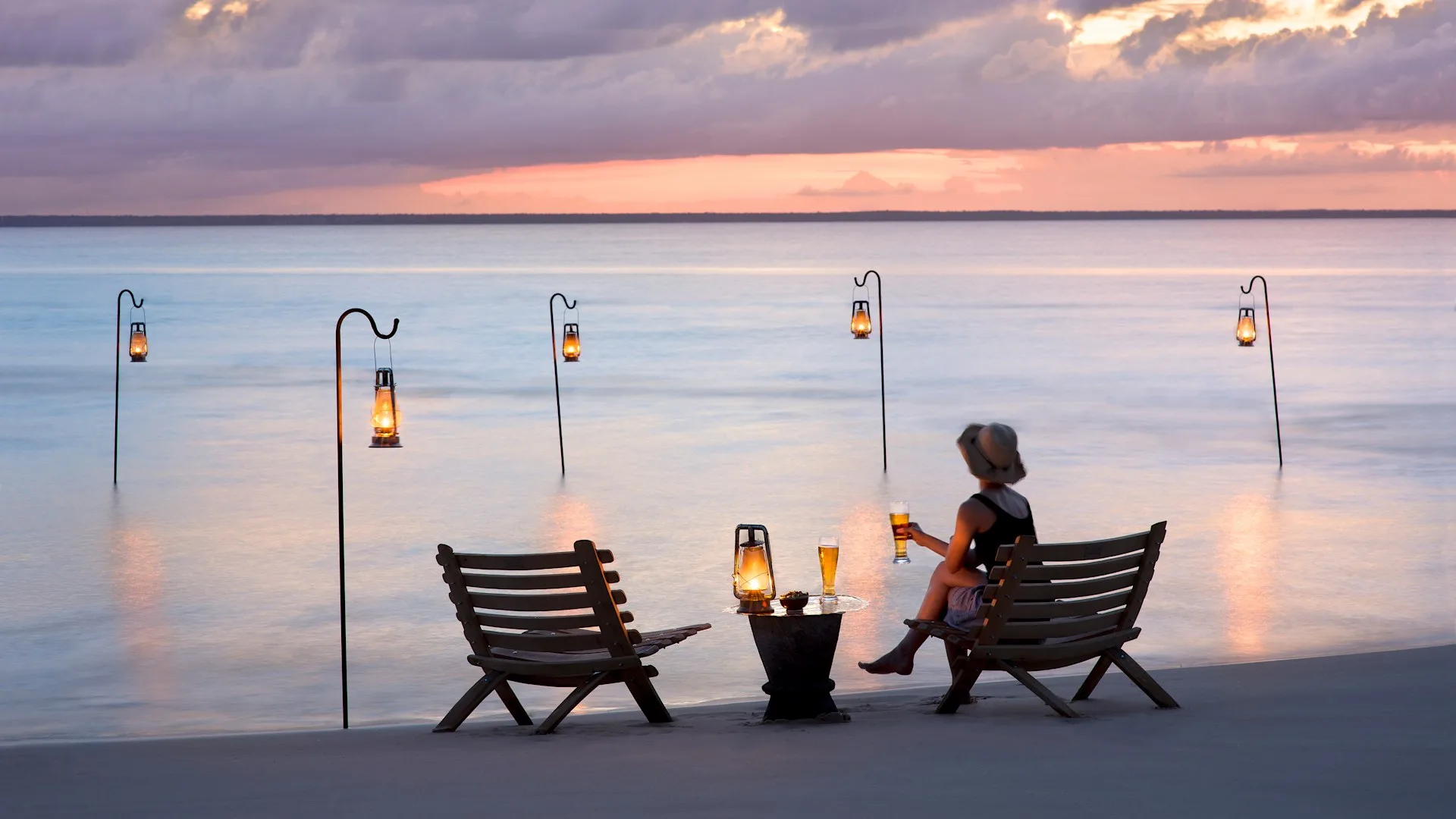 Sundowner drinks at the water's edge at dusk, Benguerra Island, Mozambique