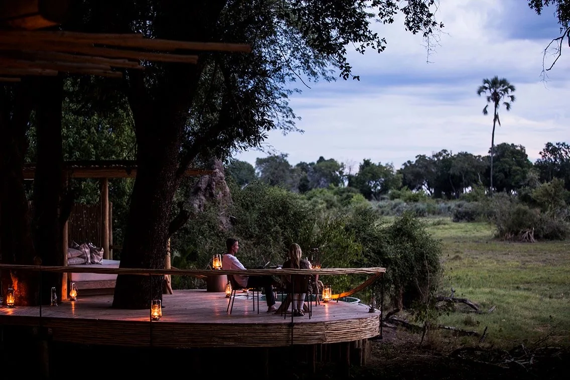 Dinner on a private deck at dusk, Mombo Camp, Okavango Delta
